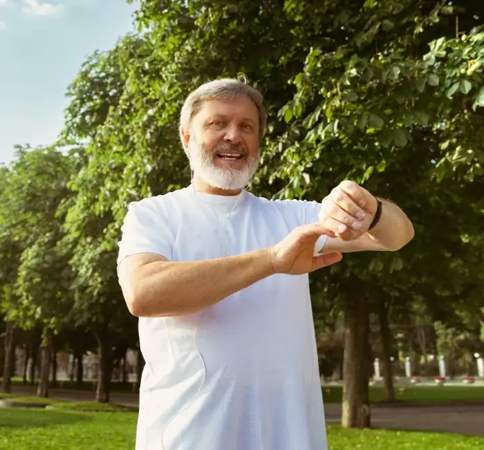 A man outdoors holding a bottle of the supplement